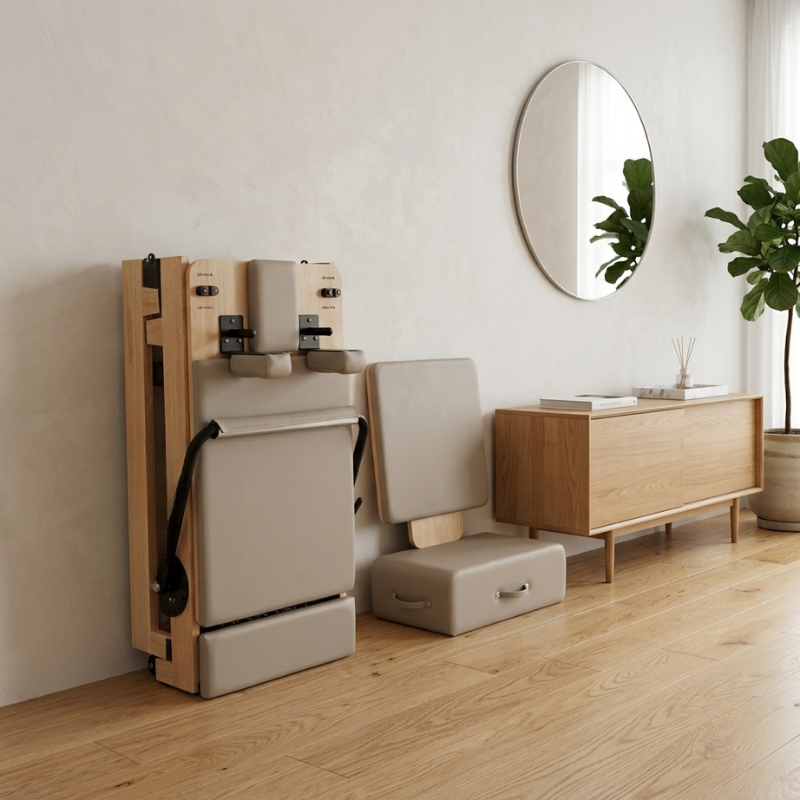 Reformys Cloud Assisted Folding Pilates Reformer in Beige stored against a lounge room wall